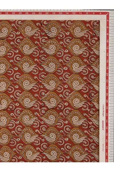 A square piece of fabric or paper with a repeating batik-style swirl pattern in rust red, tan, and cream, shown flat with a measuring ruler along the top and right edges.